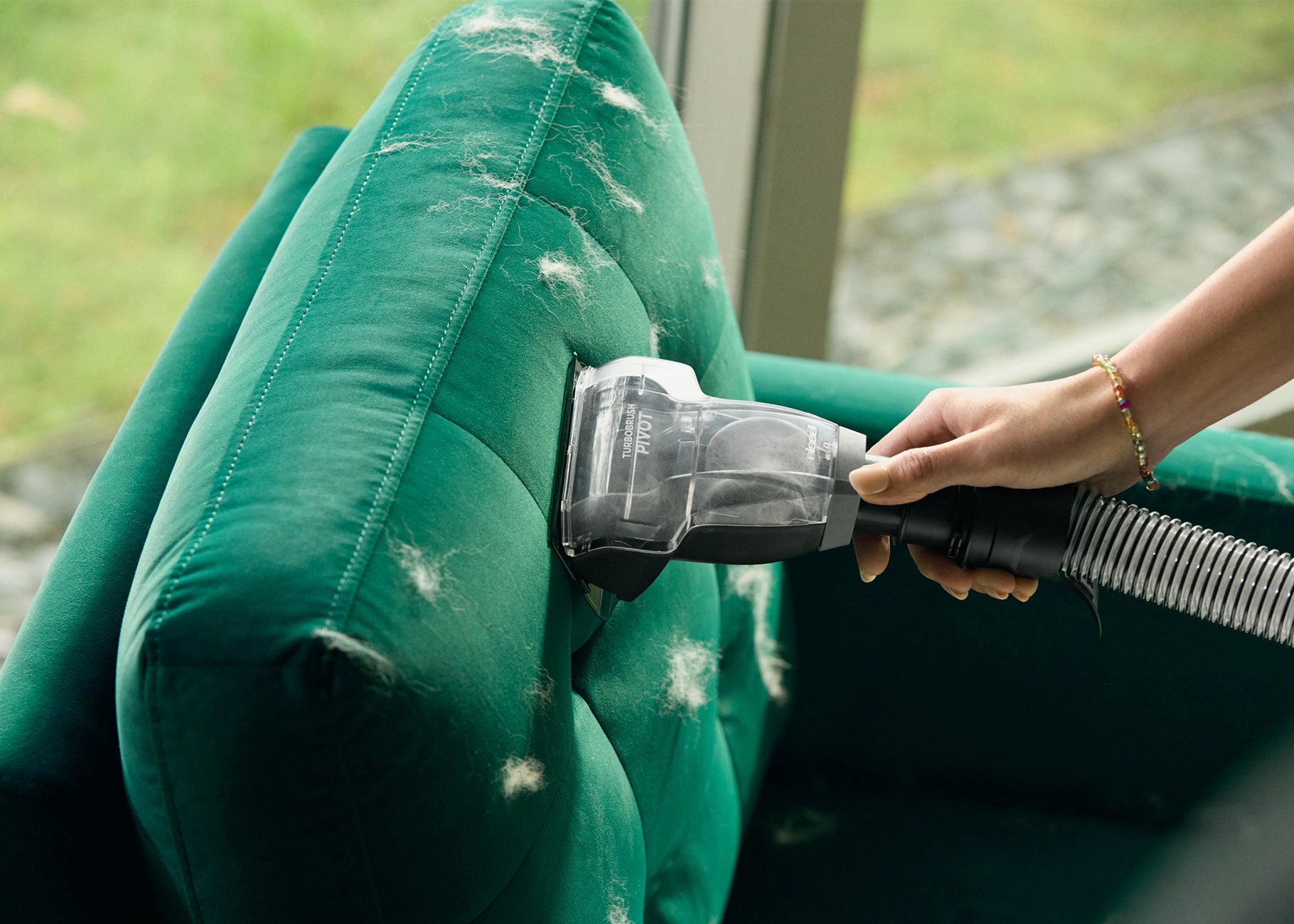 Using TurboBrush tool on hose to vacuum pet hair from upholstery