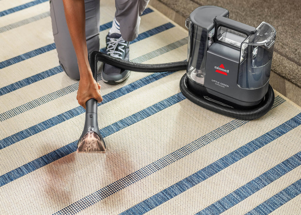 Using Little Green Cordless SmartMix portable Carpet Cleaner to clean stain from area rug