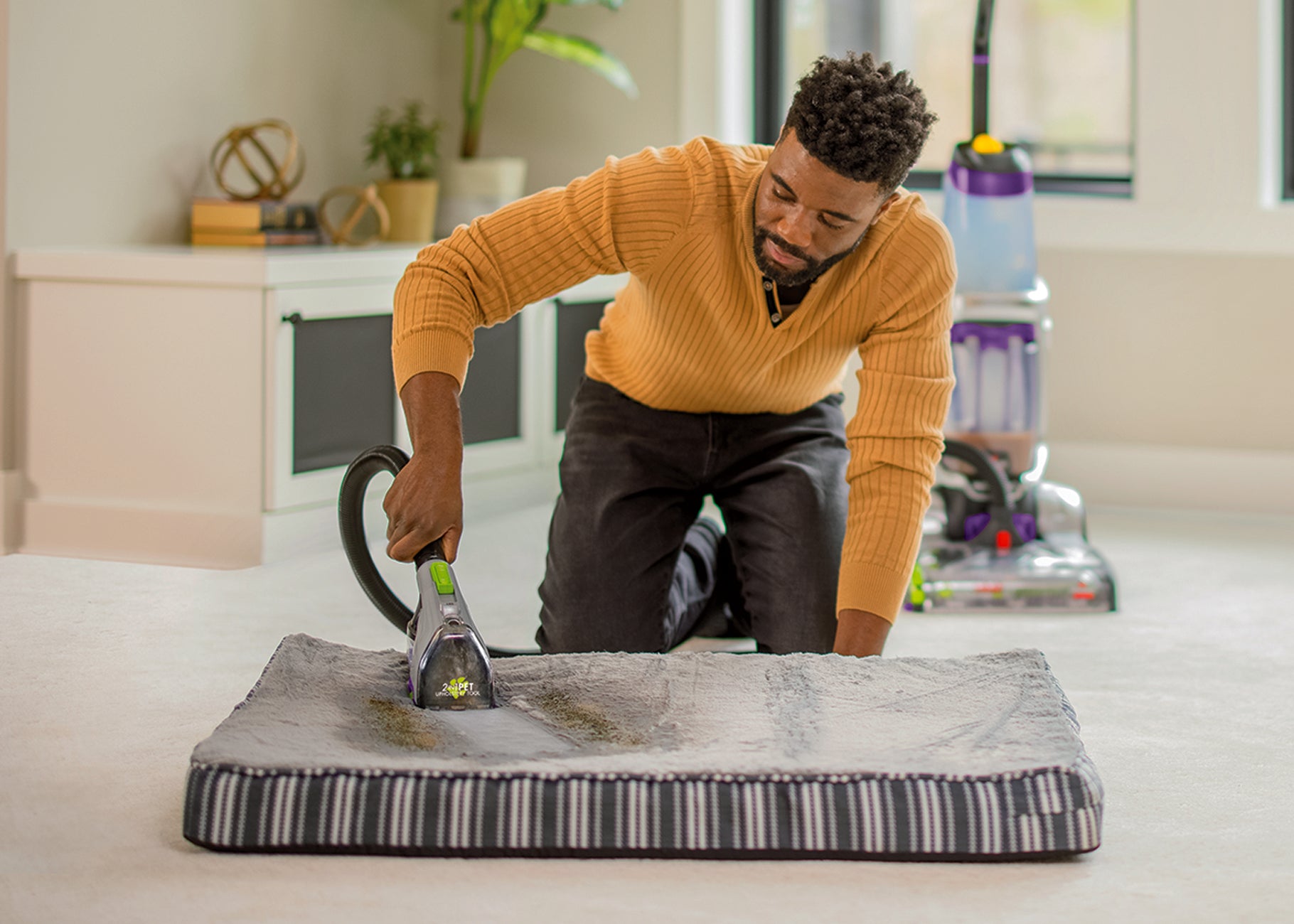 Using hose of upright carpet cleaner to clean pet bed.