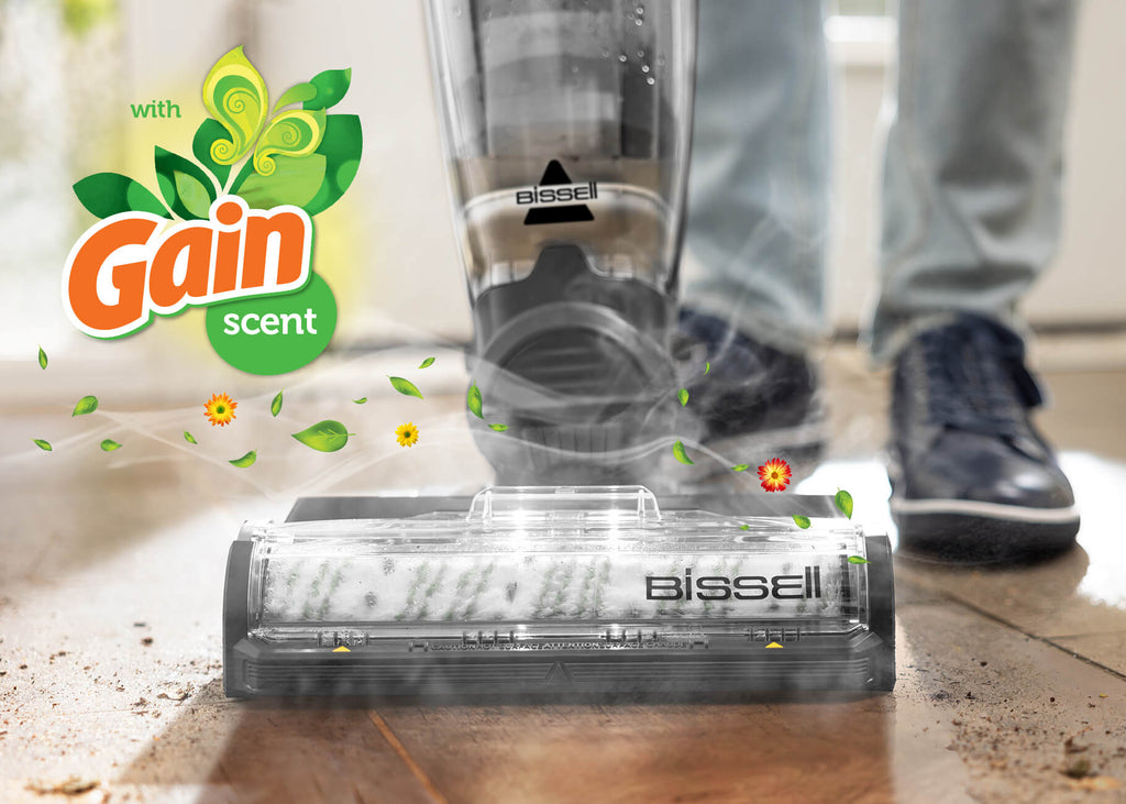 CrossWave vacuuming and mopping mud from hard flooring with Gain Logo in corner