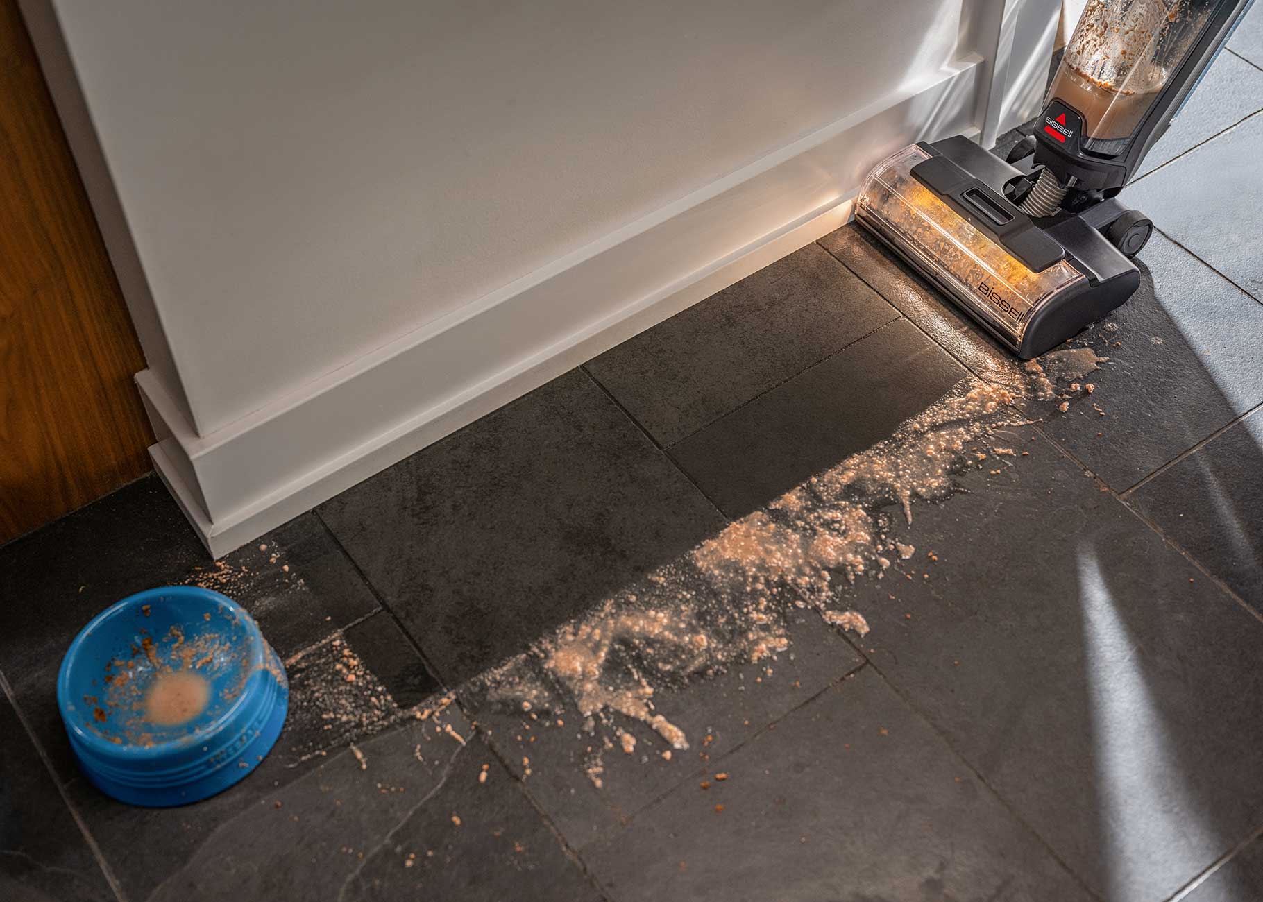 vacuuming and mopping wet spill along edge of floors
