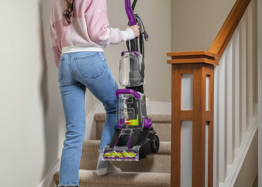 Carrying upright carpet cleaner up the stairs